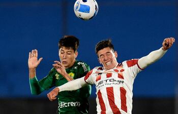 El zaguero paraguayo Juan Miguel Ojeda (i), del Cuiabá, salta en procura del balón ante Thiago Borbas, de River Plate de Uruguay, durante el partido que disputaron anoche en Montevideo.