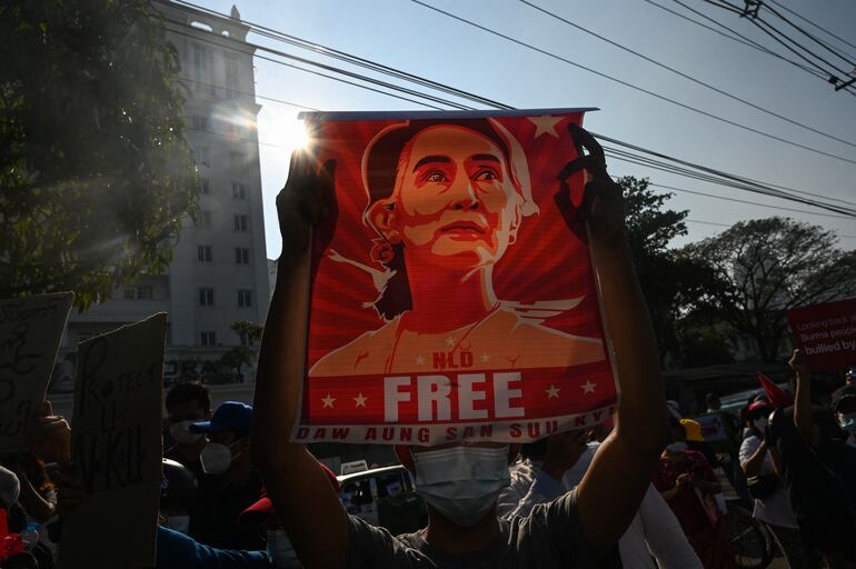 A protester holds up a poster featuring Aung San Suu Kyi during a demonstration against the military coup at in front of the Central Bank of Myanmar in Yangon on February 15, 2021. (Photo by Sai Aung Main / AFP)