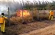 Bomberos tratan de sofocar las llamas que emergen desde el terreno de Manufactura de Pilar y amenazan el aeródromo de la capital del Ñeembucú.
