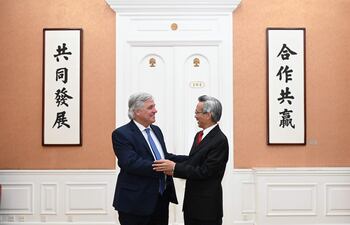 Fotografía cedida hoy por el Ministerio de Relaciones Exteriores de Uruguay que muestra al canciller Francisco Bustillo (i) mientras saluda al presidente de la Asociación de Amistad del Pueblo Chino con el Extranjero, Lin Songtian, durante una reunión en Pekín (China).