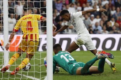 El delantero del Real Madrid Rodrygo Goaes (d) lucha con Paulo Gazzaniga (c), guardameta del Girona FC, durante el partido de LaLiga de fútbol de Primera División disputado este domingo en el estadio Santigo Bernabéu, en Madrid.