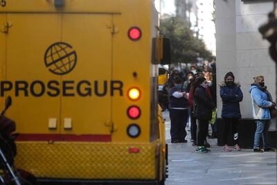Personas realizan una fila hoy para ingresar a un banco, en Buenos Aires (Argentina).