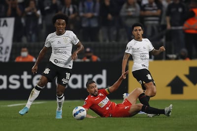 Willian de Corinthians (izq.) disputa el balón contra Rodrigo Ramallo de Always Ready (abajo), hoy, durante el final de un partido del Grupo E de la Copa Libertadores, disputado en el estadio Arena de Sao Paulo, en Sao Paulo (Brasil).