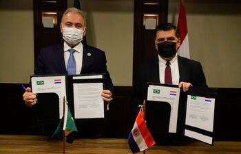 Los ministros de Salud, Marcelo Queiroga (Brasil) y Julio Borba (Paraguay) muestran el acuerdo de vigilancia sanitaria firmado durante un encuentro en Foz de Yguazú.