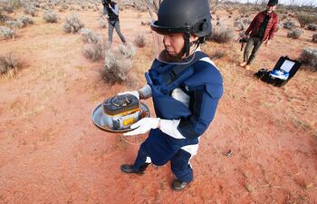 En esta imagen distribuida por la Agencia Japonesa de Exploración Aeroespacial se muestra una escena de la recuperación de las muestras de un asteroide, que dejó caer Hayabusa en el Sur de Australia.