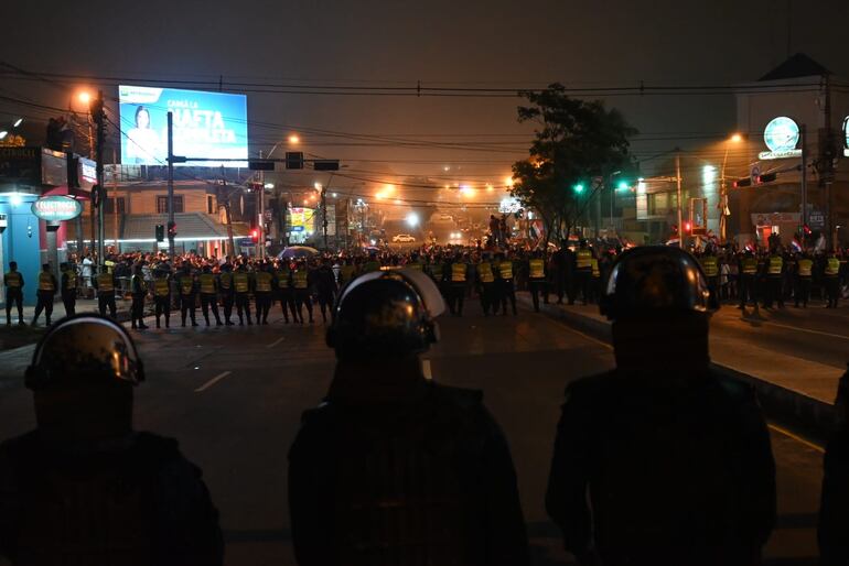 Policías en formación resguardando la sede del TSJE, sobre la avenida Eusebio Ayala, ante el avance de los manifestantes.