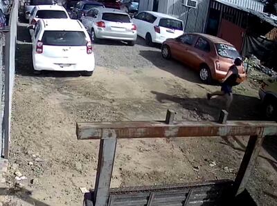 La víctima corre entre los autos  para tratar de  salvar su  vida.