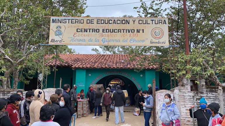 Los padres retiraros los kit de la escuela donde asisten sus niños.