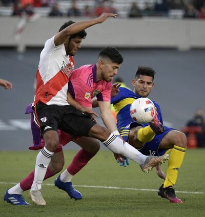 Robert Rojas en acción ofensiva ante el arquero de Boca Agustín Rossi y el zaguero Carlos Zambrano, durante el partido que River ganó ayer 2-1. (AFP).