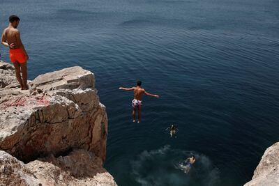 Un hombre se sumerge en el mar durante una ola de calor en Varkiza, cerca de Atenas, (Grecia).