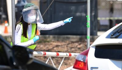 Una voluntaria dirige a conductores a un puesto móvil de pruebas de COVID-19 en Los Ángeles, California.