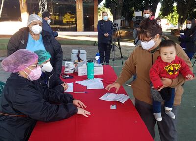 Una mujer acude para que su bebé reciba la dosis contra la influenza en el vacunatorio de la Aso de Funcionarios de Hacienda, en Lambaré.