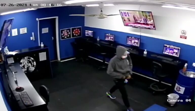 El asaltante a su salida del negocio, luego de tomar la millonaria suma de plata.