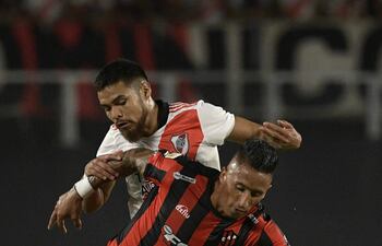 Lucas Barrios, en frente, luchando por la posesión del balón con Paulo Díaz, en un partido de Patronato ante River.
