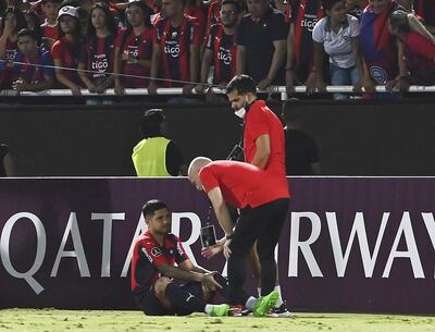 Sergio Díaz, en el gramado, cuando es asistido por el médico  Daniel Pineda y Nigel Navarro.
