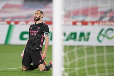 Real Madrid's French forward Karim Benzema kneels on the field during the Spanish league football match Granada FC against Real Madrid CF at the Nuevo Los Carmenes stadium in Granada on May 13, 2021. (Photo by JORGE GUERRERO / AFP)