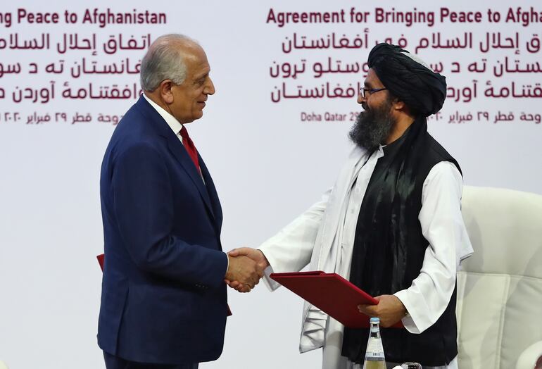 Zalmay Khalilzad, representante estadounidense en Afganistán, con el líder talibán Mullah Abdul Ghani Baradar durante una ceremonia en Doha, en febrero.