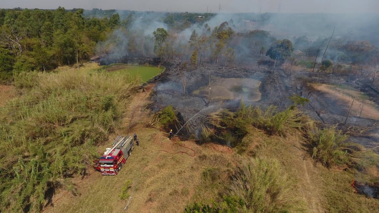 El cuerpo de bomberos voluntarios de Coronel Oviedo trabajando incesantemente para sofocar el fuego.