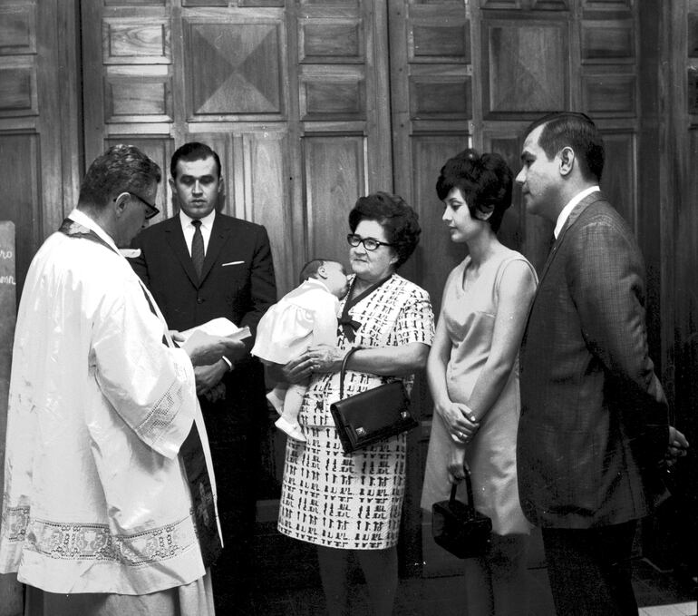 Ligia Mora de Stroessner y su hijo Gustavo apadrinando a una bebé en la Iglesia de San José.