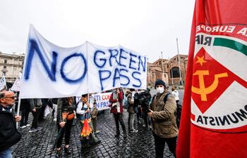 Manifestantes sostienen un cartel en contra del pasaporte sanitario obligatorio.