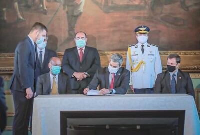 Mario Abdo Benítez (c) firma el documento. Observan  el titular del Congreso, Óscar Salomón (izq.), y presidente de la Corte, Alberto Martínez Simón (der.). Fue ayer en el  Palacio de López.
