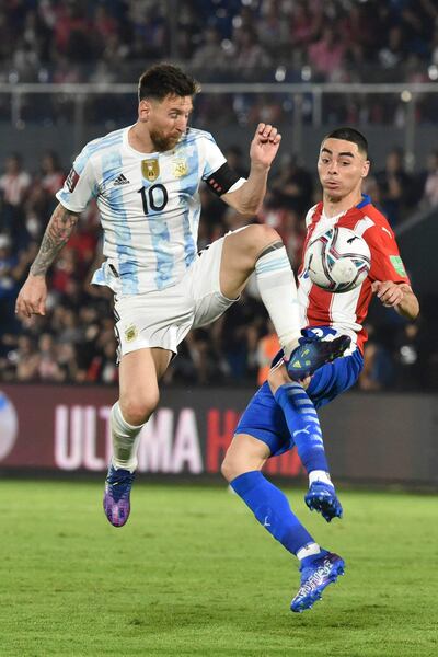Peligroso cruce de piernas entre el argentino Lionel Messi y el paraguayo Miguel Almirón. (AFP).