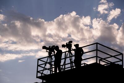 Dos camarógrafos en la transmisión de un partido de fútbol.
