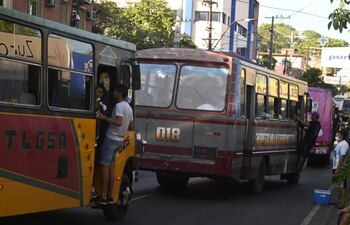 En un caótico retorno de Caacupé, peregrinos deben viajar en las estriberas de los buses.