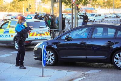 Una policía local da el alto a un vehículo en la primera jornada de restricciones aplicadas a las áreas sanitarias de Miguel Servet y Doctor Trueta de la localidad madrileña de Alcorcón.