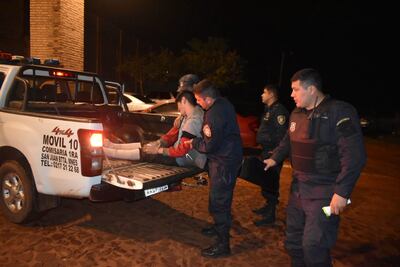 Uno de los recapturados que está herido en una patrulla de la Policía.