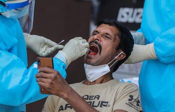 Imagen de referencia. Un hombre registra en su celular el momento en que le toman una muestra para determinar si tiene coronavirus.