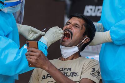 Imagen de referencia. Un hombre registra en su celular el momento en que le toman una muestra para determinar si tiene coronavirus.