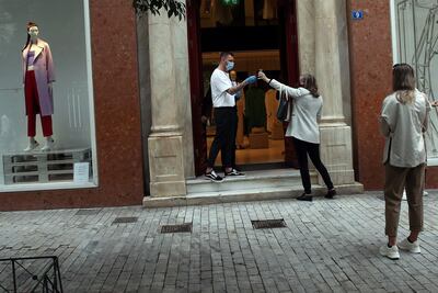 Varios empleados revisan el pasaporte covid en una tienda en Atenas, en una imagen de archivo.