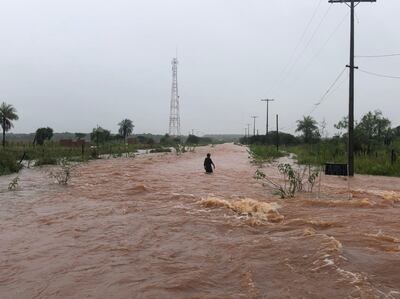 Un vecino del asentamiento Aquino Cue camina por las calles inundadas.