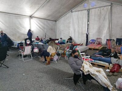 Familiares de pacientes internados por covid en el albergue en el que pasarán la noche.