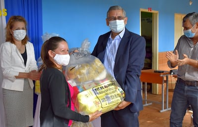 El gobernador Juan Carlos Vera entrega a una madre el paquete de alimentos.