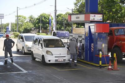 Imagen de referencia. Playeros cargando combustible en una estación de servicios de Petropar.