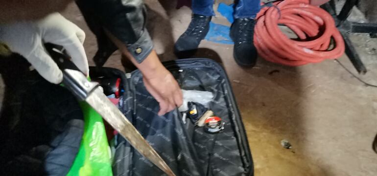  Agentes de Criminalística verifican el arma homicida, que fue encontrada en la escena del crimen.