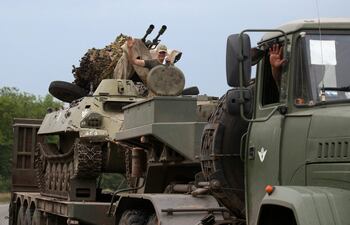 Militares ucranianos saludan a las personas mientras viajan en la región de Donetsk.