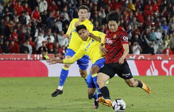 PALMA DE MALLORCA, 12/05/2023.- El centrocampista coreano del Mallorca, Kang-in Lee (d), se dispone a golpear el balón ante el centrocampista paraguayo del Cádiz, Santiago Arzamendia, durante el encuentro correspondiente a la jornada 34 de primera división que han disputado ayer viernes en el estadio de Son Moix, en Palma de Mallorca. EFE/CATI CLADERA.