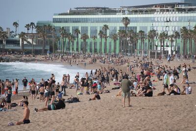 La gente disfruta de una mañana en la playa en Barcelona.