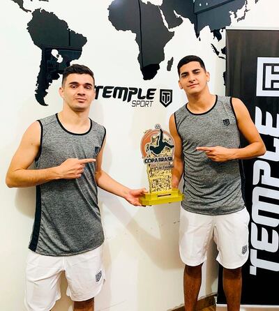 Fernando “Chore’i” Lugo y Esteban Dávalos muestran el trofeo que los acredita como campeones de la Copa das Favelas.