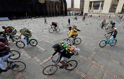 Jóvenes cargan coronas fúnebres en bicicletas durante un plantón en apoyo a la moción de censura contra el ministro de Defensa colombiano, Diego Molano, frente al Capitolio Nacional en la Plaza de Bolívar, en Bogotá (Colombia).