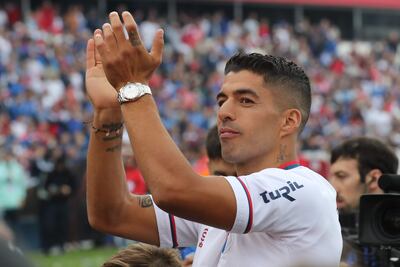 El futbolista uruguayo Luis Suárez saluda hoy con la camiseta del Nacional durante su recibimiento como nuevo fichaje del club, en el estadio Gran Parque Central en Montevideo (Uruguay).