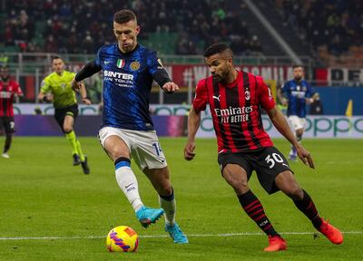 El croata Ivan Perisic (i), del Inter, disputa el balón con el brasileño Messias Junior, del AC Milan, durante el partido disputado ayer en el estadio Giuseppe Meazza.