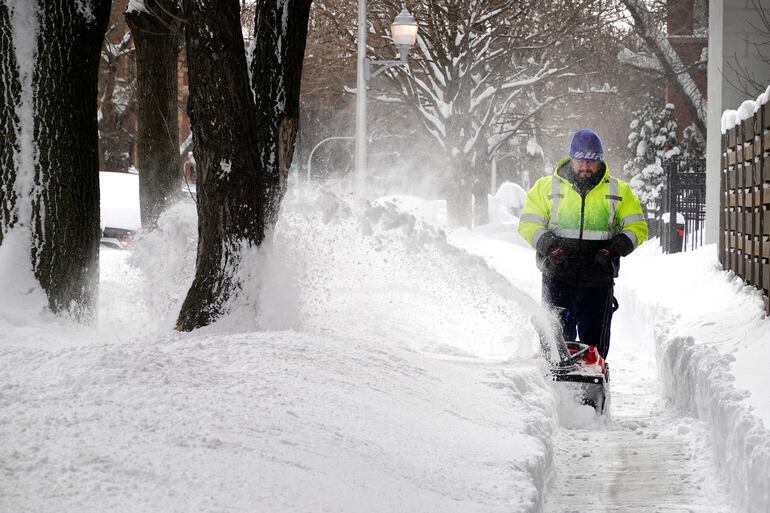 CHICAGO, ILLINOIS - FEBRUARY 16: A worker clears snow from a sidewalk in the Humboldt Park neighborhood on February 16, 2021 in Chicago, Illinois. Residents are digging out this morning after snowstorm coupled with lake-effect snow dumped more than 17 inches of snow in the some areas of the city.   Scott Olson/Getty Images/AFP (Photo by SCOTT OLSON / GETTY IMAGES NORTH AMERICA / AFP)