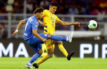 Ángel Romero (i) de Cruz Azul disputa el balón con Hugo Ayala de Tigres.