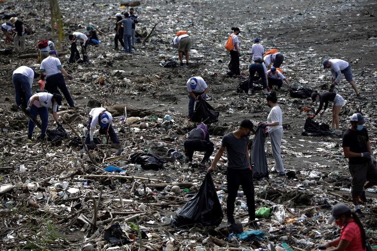 Voluntarios recogen basura durante una jornada de limpieza de playas hoy, en Ciudad de Panamá (Panamá).