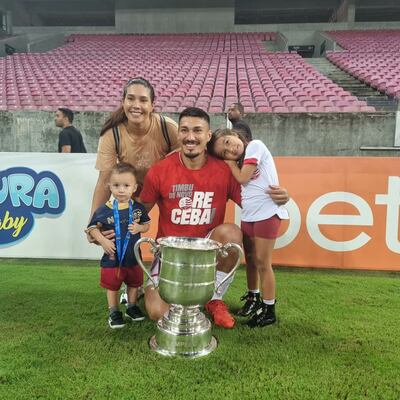 Richard Franco posa con su esposa e hijos junto al trofeo.