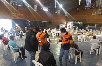 Personal de Salud toma los datos de personas aguardando para ser inmunizadas.